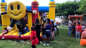 Kids jumping on the Smiley Face bounce house